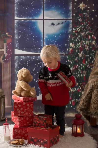 Lindo menino, abrindo presentes na noite de Natal, secr — Fotografia de Stock