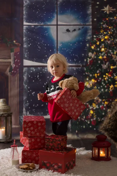 Όμορφο μικρό αγόρι, ανοίγοντας δώρα τη νύχτα των Χριστουγέννων, secr — Φωτογραφία Αρχείου