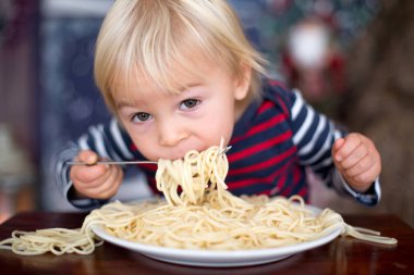 Tatlı çocuk, oğlum, evde spagetti yiyor.