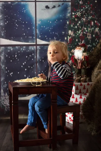 Doce criança, menino, comer espaguete em casa — Fotografia de Stock