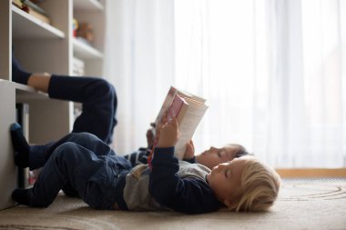 Tatlı çocuk, oğlum, evde kitap okuyor.