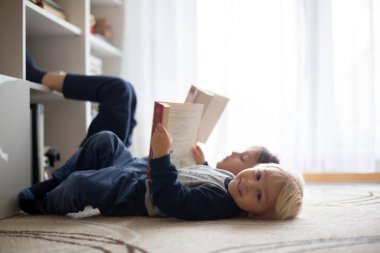 Tatlı çocuk, oğlum, evde kitap okuyor.