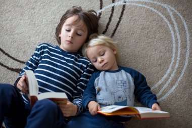Tatlı çocuk, oğlum, evde kitap okuyor.
