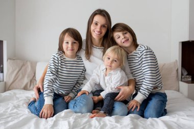 mutlu anne ve çocuklarının yatakta yatarken