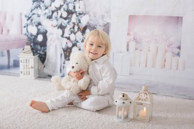 Süslü beyaz giyinmiş güzel sarışın çocuk.