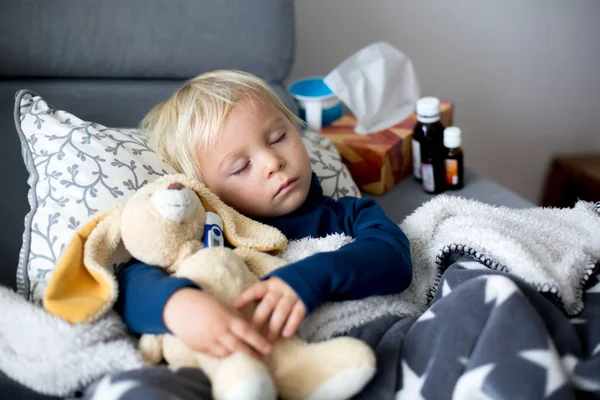 Niño rubio, durmiendo en el sofá en la sala de estar, acostado d — Foto de Stock