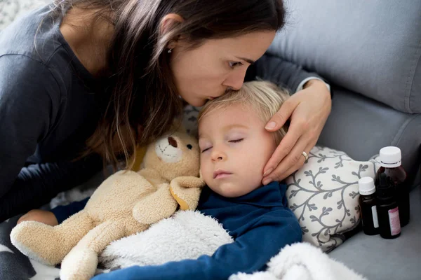 Biondo bambino ragazzo, dormire sul divano in soggiorno, sdraiato d — Foto Stock