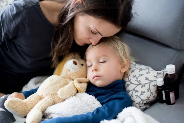 Biondo bambino ragazzo, dormire sul divano in soggiorno, sdraiato d — Foto Stock