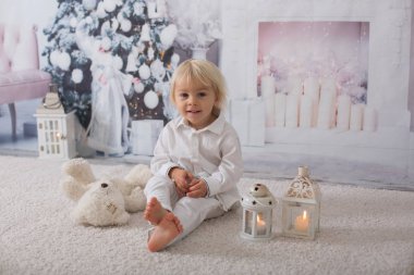 Süslü beyaz giyinmiş güzel sarışın çocuk.