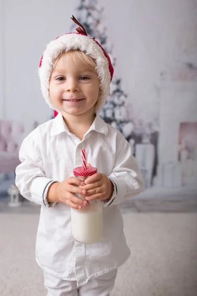 Hermoso niño con sombrero rojo de santa, sosteniendo la botella con mi —  Fotos de Stock