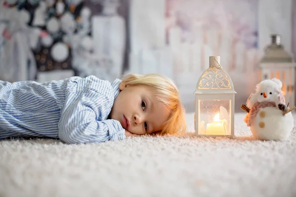 Doce criança boylying no chão em casa com velas, esperando — Fotografia de Stock