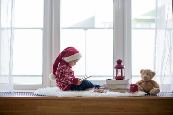 Sweet blonde child, boy, sitting on window shield with teddy bea — Stockfoto