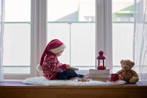 Sladké blondýny dítě, chlapec, sedí na štítu okna s teddy bea — Stock fotografie