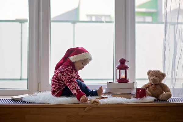 Sladké blondýny dítě, chlapec, sedí na štítu okna s teddy bea — Stock fotografie