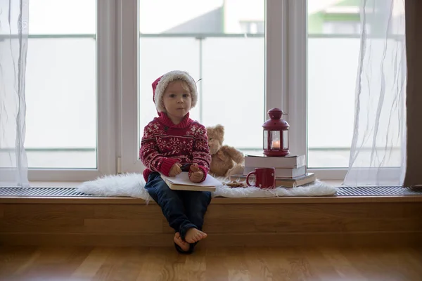 Sweet blonde child, boy, sitting on window shield with teddy bea — Stock Photo, Image