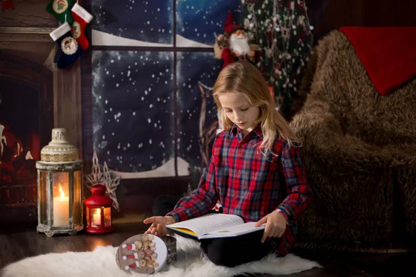 Linda niña preescolar, sentado al lado del árbol de Navidad, la apertura de pre — Foto de Stock