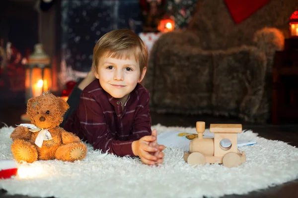 Cute preschool boy, sitting next to christmas tree, playing with — Stock Photo, Image