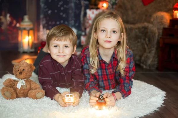 Roztomilý školka chlapec a dívka, sourozenci, sedí vedle vánoc — Stock fotografie