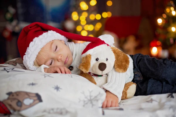 Sladká krásná blond batole chlapec, spí v posteli s hračkou — Stock fotografie