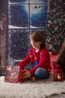 Güzel okul çocuğu, Noel gecesi hediyeleri açıyor.