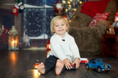 Tatlı çocuk, yerde bir sürü araba oyuncağı oturuyor, pla