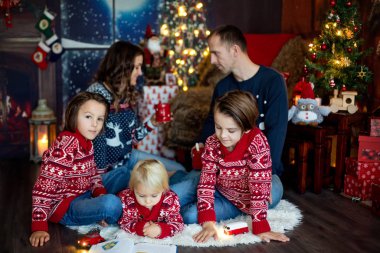 Mutlu gülümseyen bir aile, anne, baba ve üç erkek çocuk.