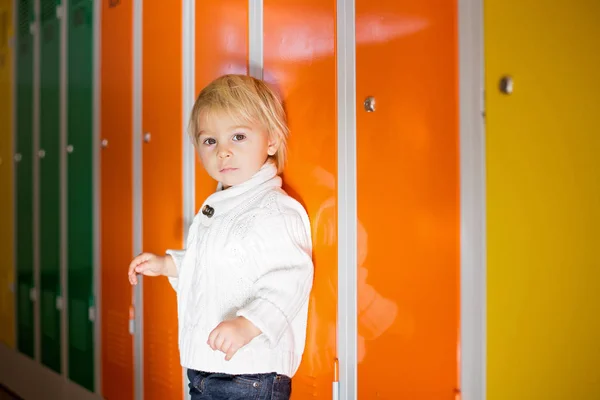Солодка блондинка малюк стоїть перед шафками в кинджалі — стокове фото