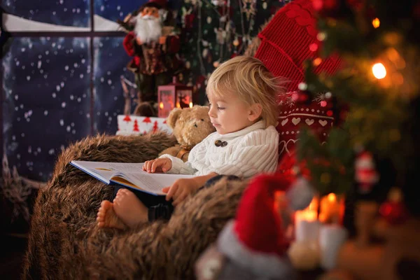 Lindo niño pequeño, sentado alrededor del árbol de Navidad en silla acogedora, r —  Fotos de Stock