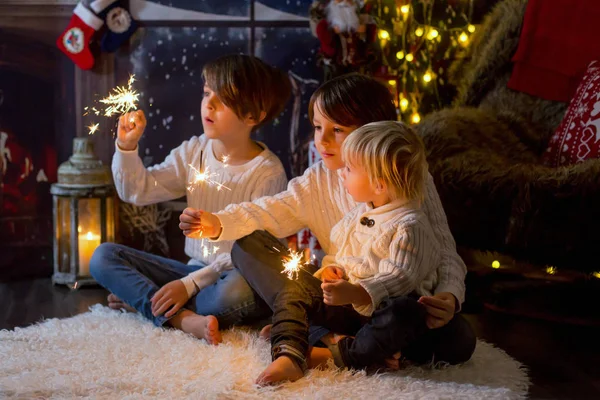 Preschool children, holding sparkler, celebrating new years eve — Stockfoto