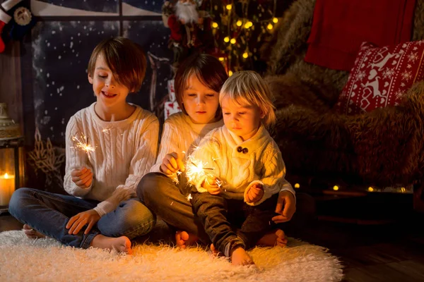 Preschool children, holding sparkler, celebrating new years eve — Stockfoto