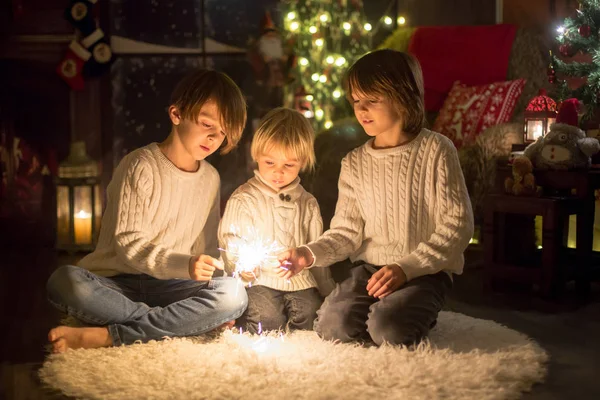 Preschool children, holding sparkler, celebrating new years eve — Stockfoto