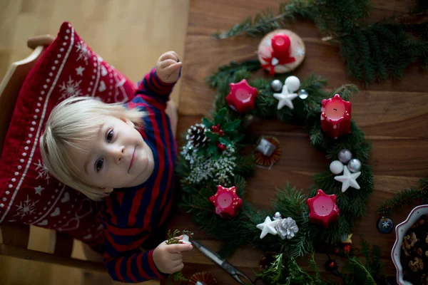 可愛いですブロンド幼児男の子,作るアドベンチャー花輪に家 — ストック写真