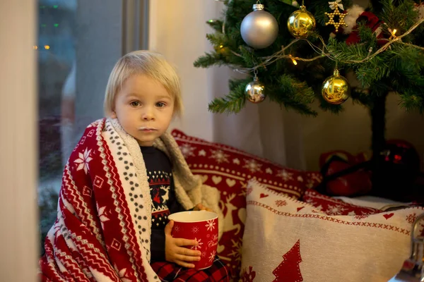 Dolce bambino ragazzo in pigiama di Natale, seduto sulla finestra vicino t — Foto Stock