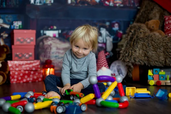 Sweet blonde toddler boy, playing with plastic construction, mak — Stock Photo, Image