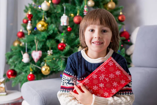 Noel hediyesi tutan sevimli okul öncesi çocuk, sevinç ve mutluluk — Stok fotoğraf