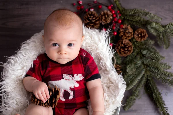 Kleiner Junge mit Weihnachtskleidung im Korb, neugierig blickend — Stockfoto