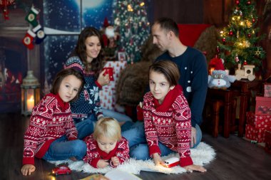 Mutlu gülümseyen bir aile, anne, baba ve üç erkek çocuk.