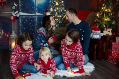 Mutlu gülümseyen bir aile, anne, baba ve üç erkek çocuk.