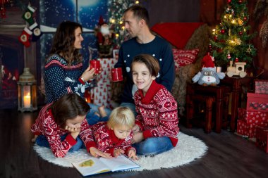 Mutlu gülümseyen bir aile, anne, baba ve üç erkek çocuk.