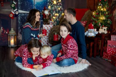 Mutlu gülümseyen bir aile, anne, baba ve üç erkek çocuk.
