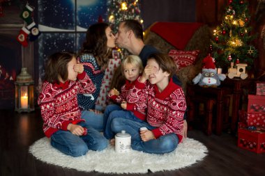 Mutlu gülümseyen bir aile, anne, baba ve üç erkek çocuk.