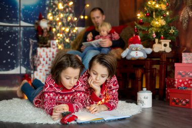 Mutlu gülümseyen bir aile, anne, baba ve üç erkek çocuk.