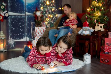 Mutlu gülümseyen bir aile, anne, baba ve üç erkek çocuk.