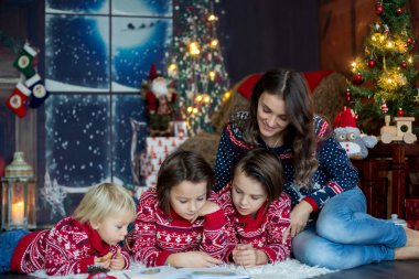 Mutlu gülümseyen bir aile, anne, baba ve üç erkek çocuk.