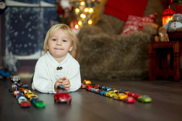 Cute toddler boy, sitting around many car toys on the floor, pla — Stock fotografie