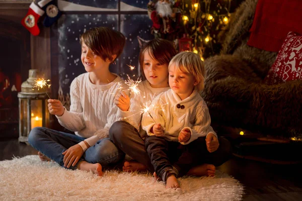 Preschool children, holding sparkler, celebrating new years eve — Stockfoto