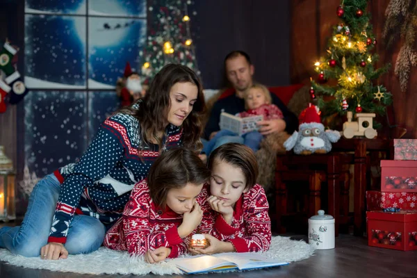 Mutlu gülümseyen bir aile, anne, baba ve üç erkek çocuk.