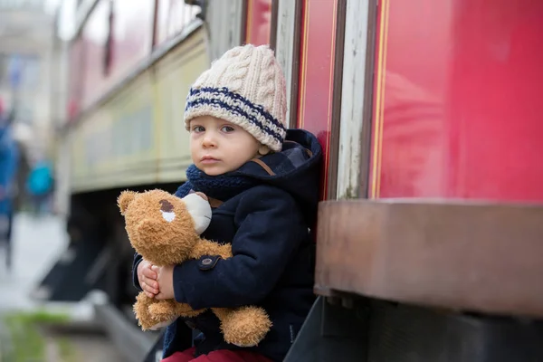 Модний маленький хлопчик з іграшкою плюшевого ведмедя в центрі міста — стокове фото
