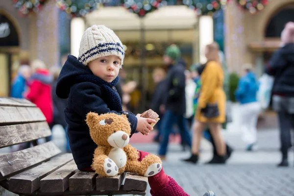 Muchacho de moda con juguete de oso de peluche, comiendo Czec tradicional —  Fotos de Stock