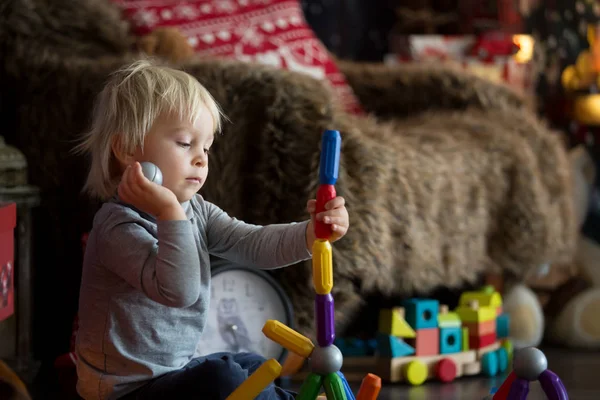 Sweet blonde toddler boy, playing with plastic construction, mak — Stock Photo, Image